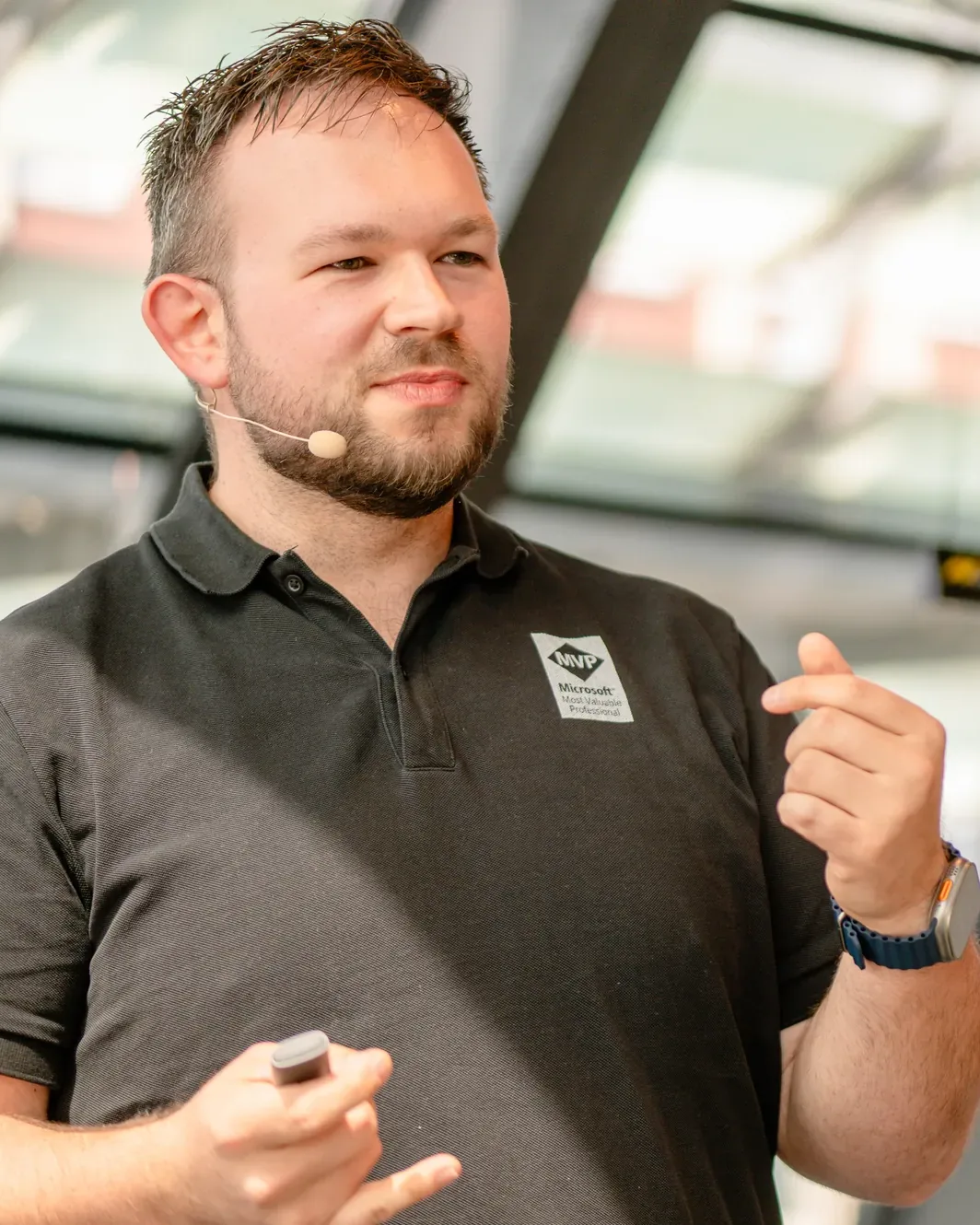 Daniel Rohregger bei einem Vortrag, mit Headset, die Hand erklärend erhoben